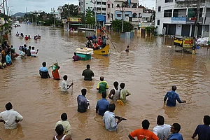 | Photo: AP : Flood in Vijayawada: People wade through a flooded road